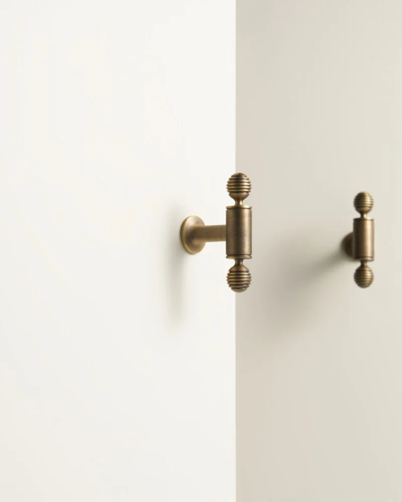 Antique brass T-bar handles on white cabinet