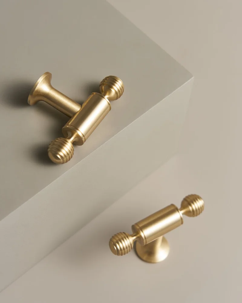 Satin brass T-bar handles on cream stone